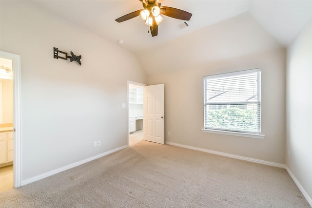 unfurnished bedroom featuring ensuite bath, ceiling fan, and lofted ceiling