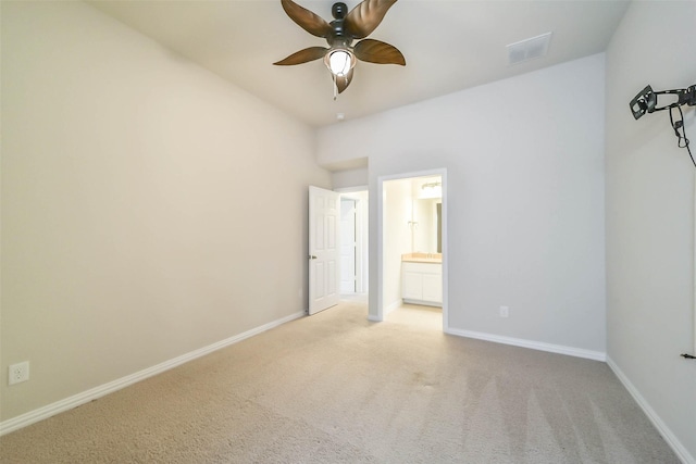 unfurnished bedroom featuring ensuite bath, ceiling fan, and light colored carpet