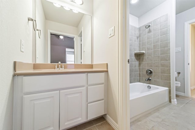 full bathroom featuring vanity, tiled shower / bath combo, toilet, and tile patterned flooring