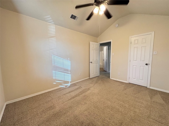 carpeted empty room featuring ceiling fan and lofted ceiling