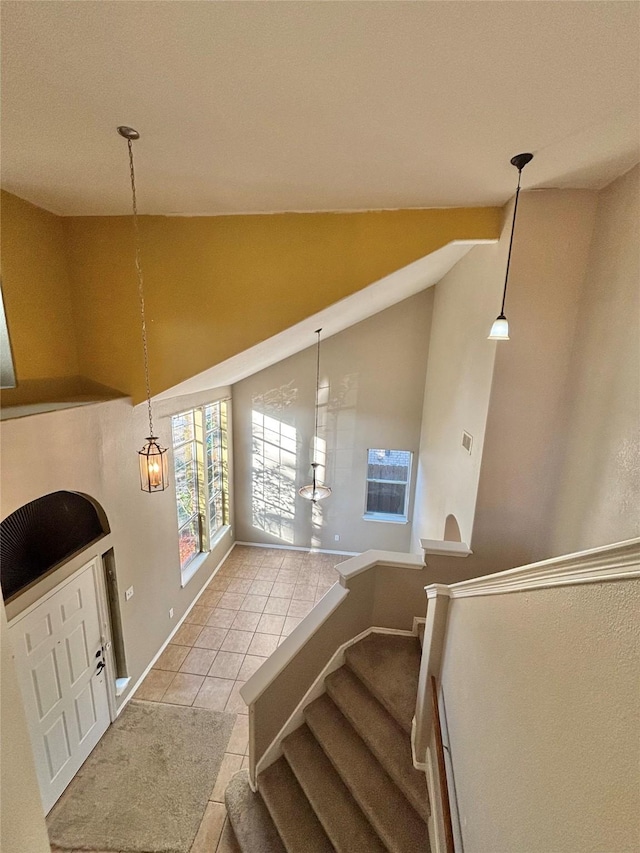 staircase with tile patterned flooring and lofted ceiling