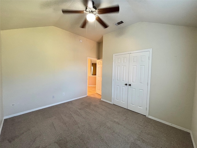 unfurnished bedroom with ceiling fan, lofted ceiling, carpet floors, and a closet