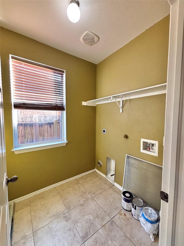 laundry area featuring gas dryer hookup, tile patterned floors, washer hookup, a textured ceiling, and hookup for an electric dryer