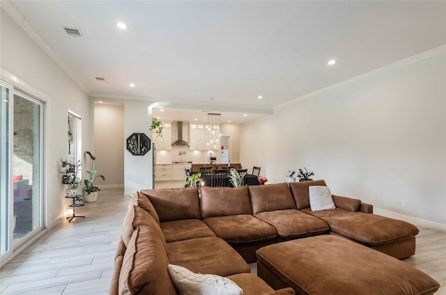 living room with plenty of natural light, light hardwood / wood-style floors, and ornamental molding