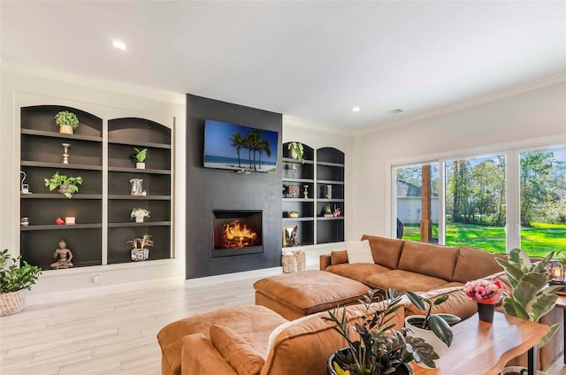 living room with built in shelves, light wood-type flooring, and ornamental molding