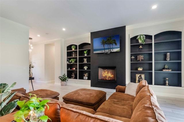 living room featuring light hardwood / wood-style floors, built in features, and ornamental molding