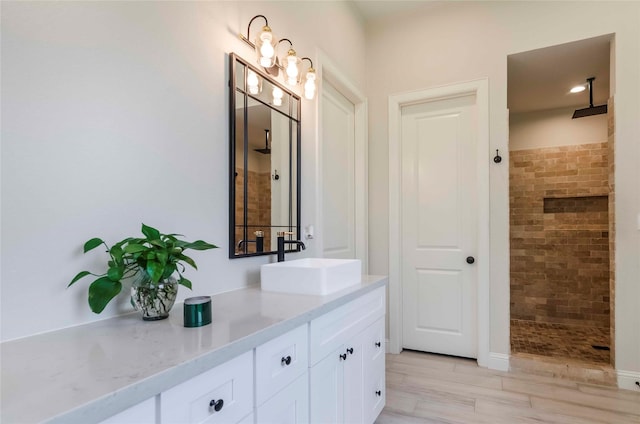 interior space with vanity and tiled shower