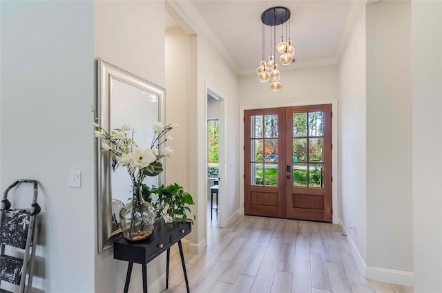 entryway with light wood-type flooring, ornamental molding, and french doors