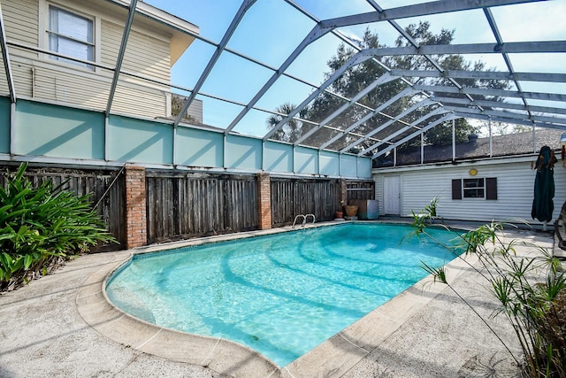 view of swimming pool with a lanai and an outbuilding