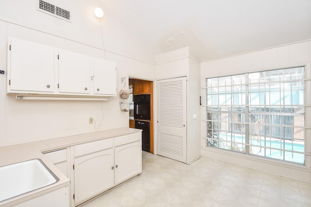 kitchen with white cabinets and black oven