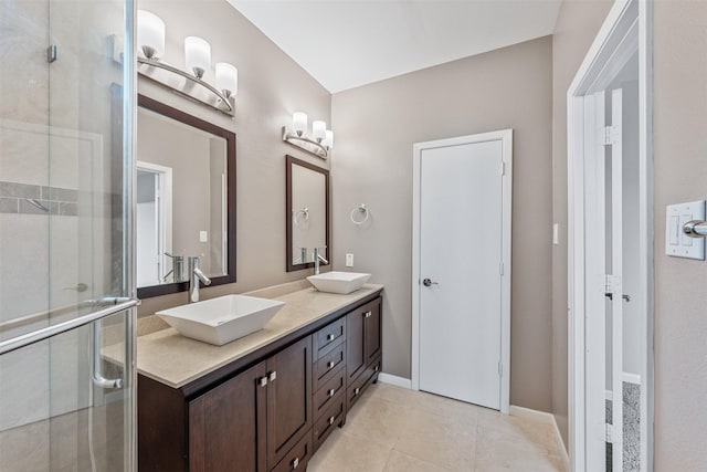 bathroom featuring a shower with door, vanity, and tile patterned flooring