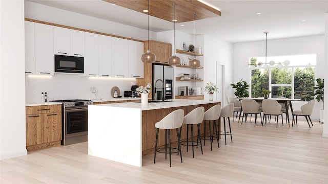 kitchen with stainless steel range, white cabinets, decorative light fixtures, and black microwave