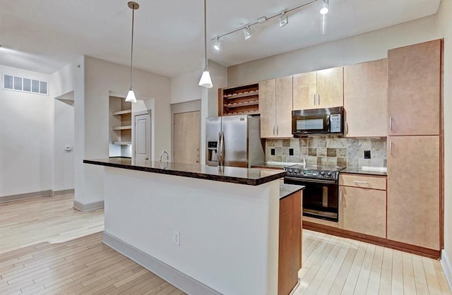 kitchen featuring stainless steel fridge, decorative light fixtures, range with electric stovetop, and a center island with sink