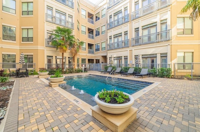 view of swimming pool with pool water feature and a patio