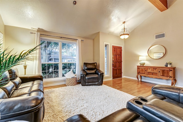 living room featuring lofted ceiling with beams and wood-type flooring