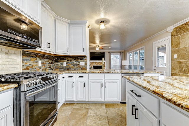 kitchen with white cabinets, sink, stainless steel appliances, and tasteful backsplash