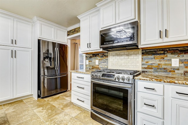 kitchen with white cabinets, decorative backsplash, light stone countertops, and stainless steel appliances