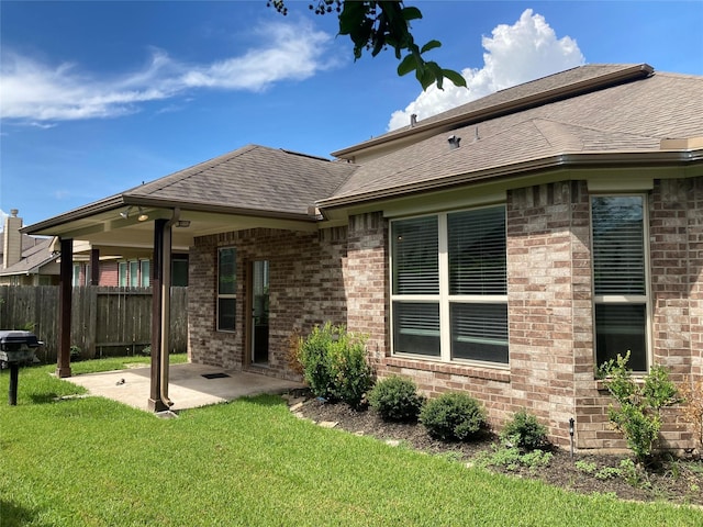 back of house with a patio area and a lawn