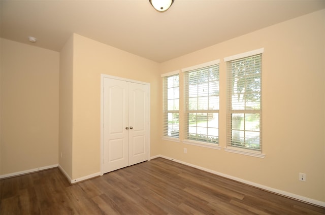 unfurnished bedroom featuring dark hardwood / wood-style floors and a closet