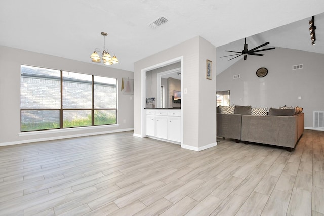 living room featuring ceiling fan with notable chandelier, lofted ceiling, and light wood-type flooring