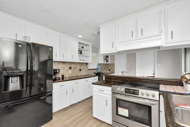 kitchen with electric stove, open shelves, dark countertops, white cabinetry, and black fridge