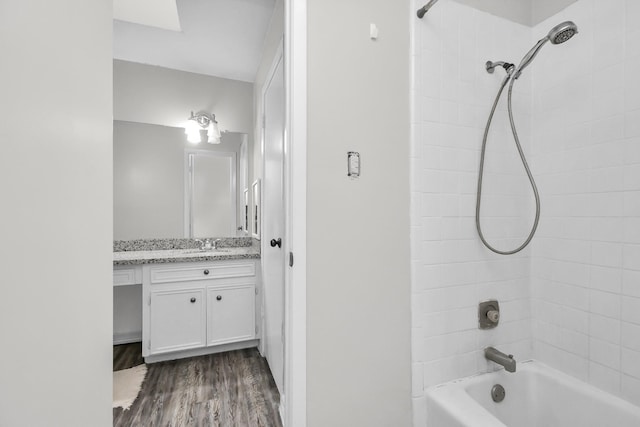 bathroom with vanity, wood-type flooring, and tiled shower / bath combo