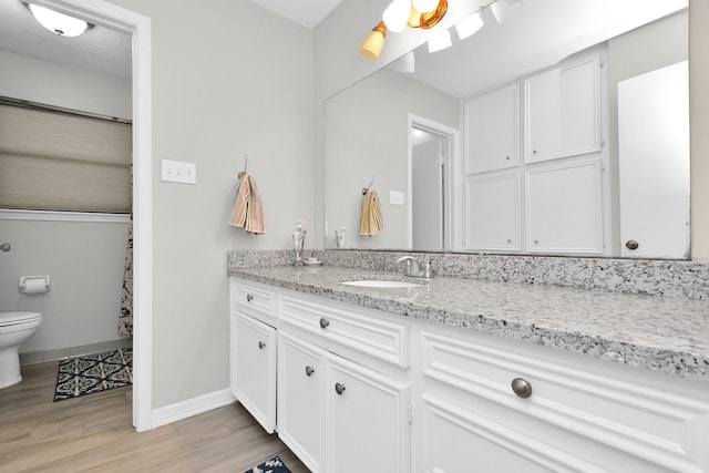 bathroom featuring hardwood / wood-style floors, vanity, and toilet