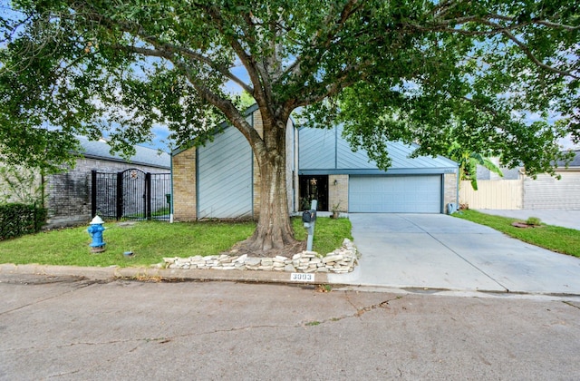 mid-century home with brick siding, concrete driveway, a gate, fence, and a garage