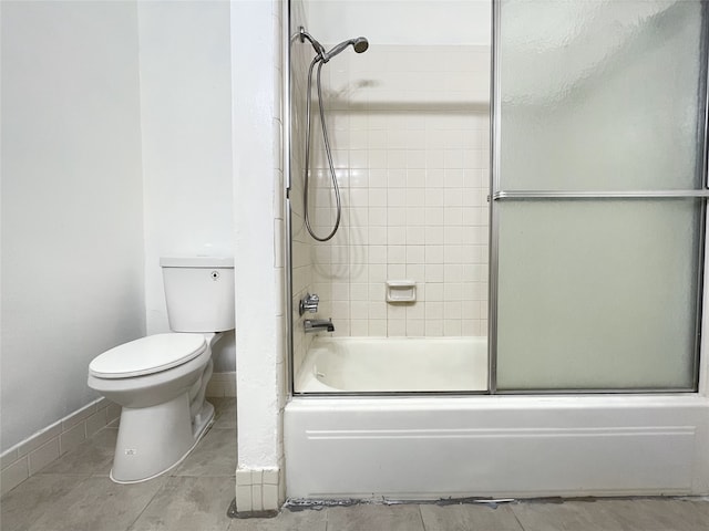 bathroom with shower / bath combination with glass door and toilet