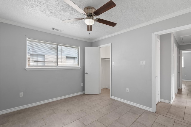 unfurnished bedroom with a walk in closet, ornamental molding, ceiling fan, light tile patterned floors, and a closet