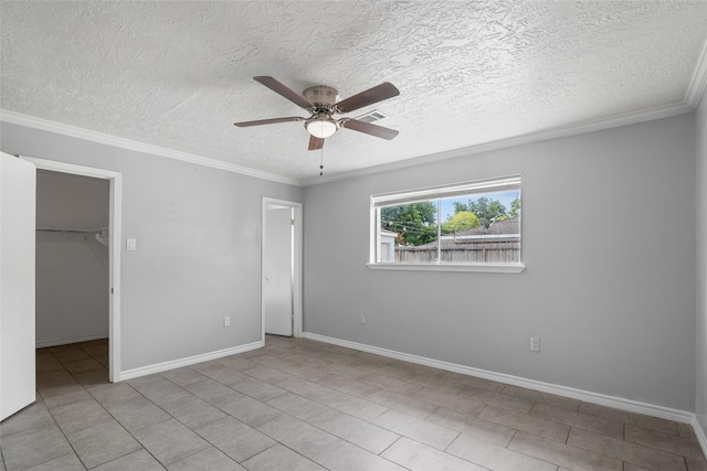 unfurnished bedroom featuring ceiling fan, a spacious closet, ornamental molding, light tile patterned flooring, and a closet