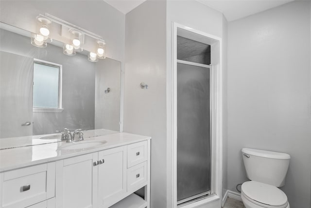 bathroom with vanity, toilet, and a shower with door