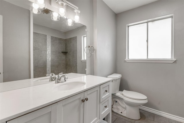 bathroom with toilet, tile patterned flooring, vanity, and tiled shower