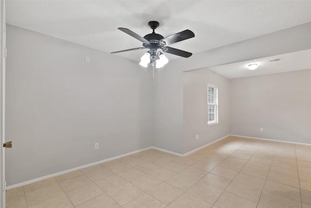 tiled empty room featuring ceiling fan