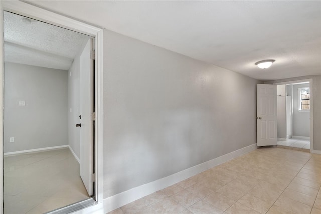 tiled spare room featuring a textured ceiling