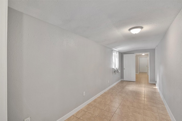 tiled spare room featuring a textured ceiling