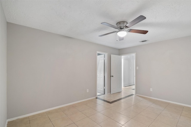 tiled empty room with a textured ceiling and ceiling fan