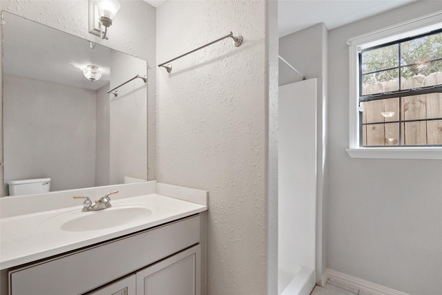 bathroom with vanity, toilet, and walk in shower