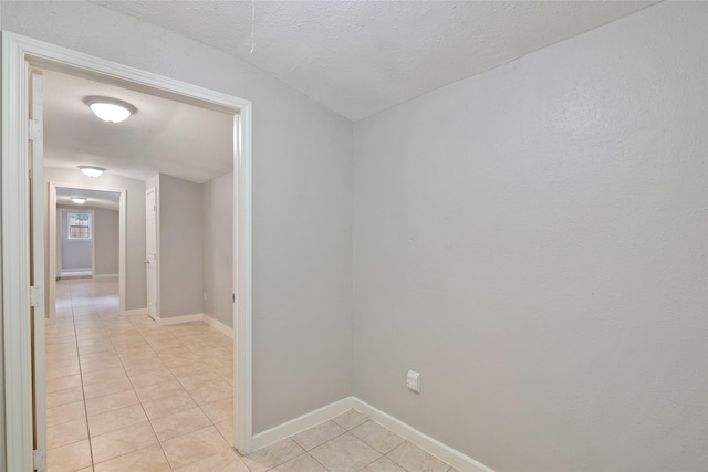 tiled empty room featuring a textured ceiling