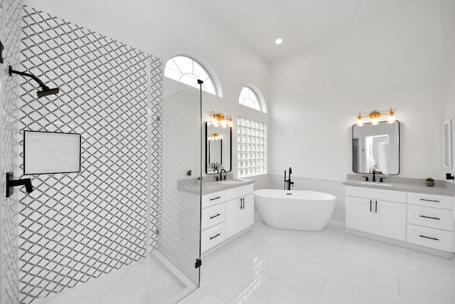 bathroom with a wealth of natural light, tile patterned flooring, vanity, and independent shower and bath