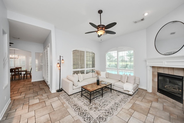 living room with ceiling fan and a fireplace