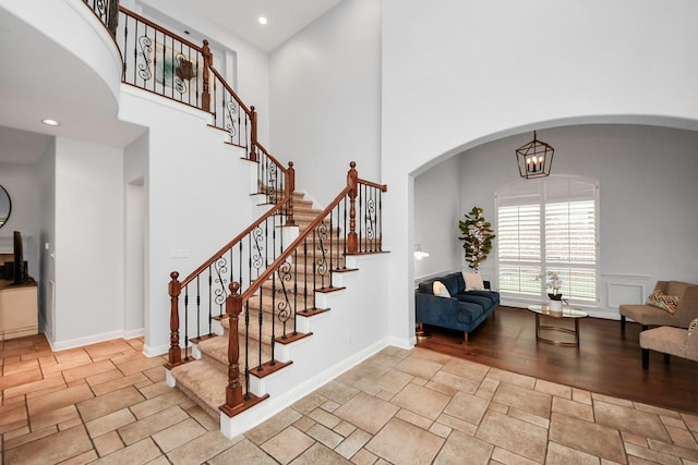 staircase featuring a high ceiling and an inviting chandelier