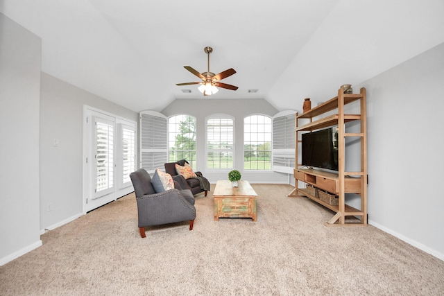 carpeted living room with ceiling fan and lofted ceiling