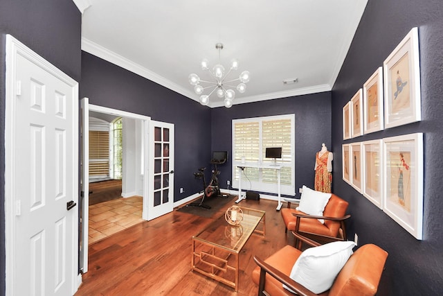 living area with a chandelier, hardwood / wood-style floors, plenty of natural light, and ornamental molding