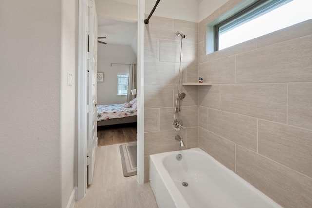 ensuite bathroom featuring ensuite bathroom, wood finished floors, and bathtub / shower combination