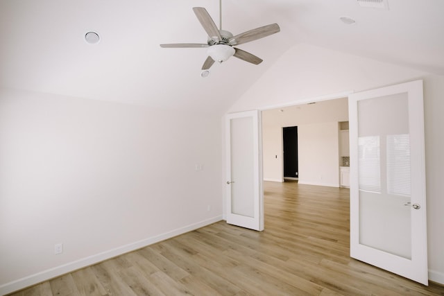 unfurnished room with vaulted ceiling, ceiling fan, baseboards, and light wood-style floors