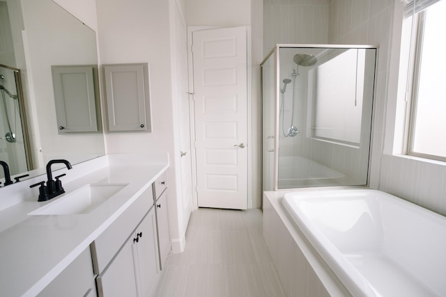 bathroom with a shower stall, a bath, and vanity