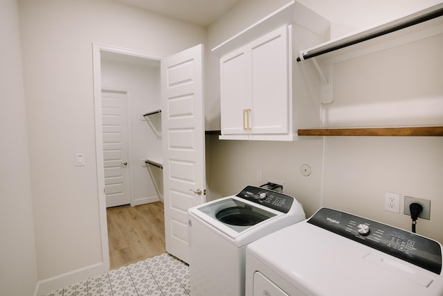 laundry room featuring washer and dryer, baseboards, cabinet space, and light floors