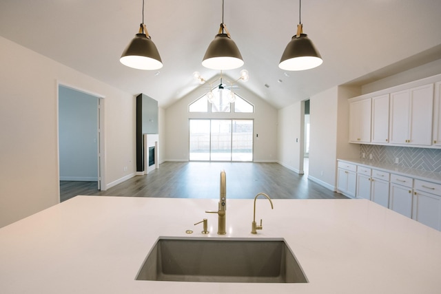 kitchen featuring light countertops, hanging light fixtures, and a sink