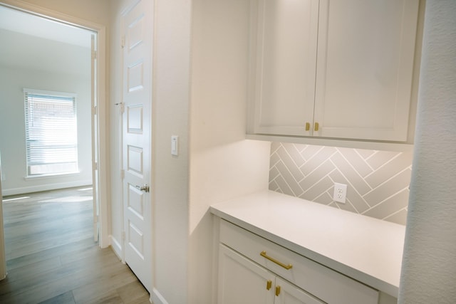 bar with tasteful backsplash, baseboards, and light wood finished floors